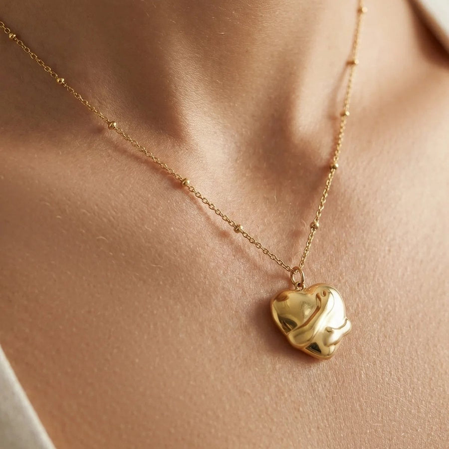 Embrace Gold Heart Necklace on the neckline, worn