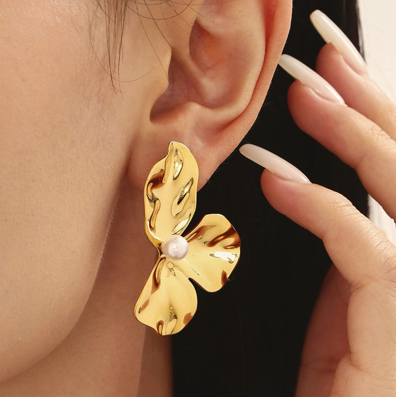 A sculpted gold petal earring, close up