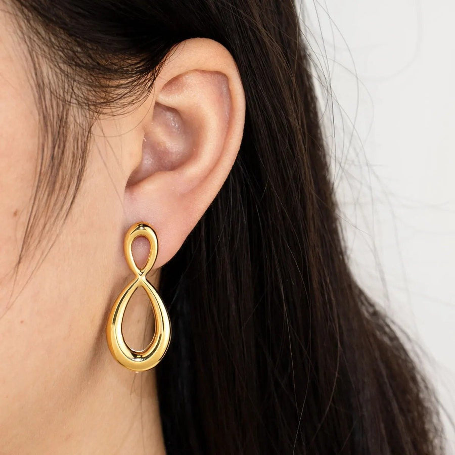 Infini Gold Infinity Drop Earrings on the ear, worn