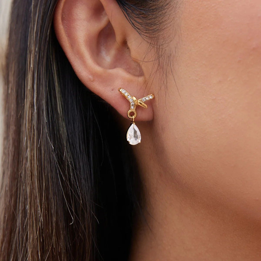 Noor Crossover Gold Teardrop Earrings on the ear, worn